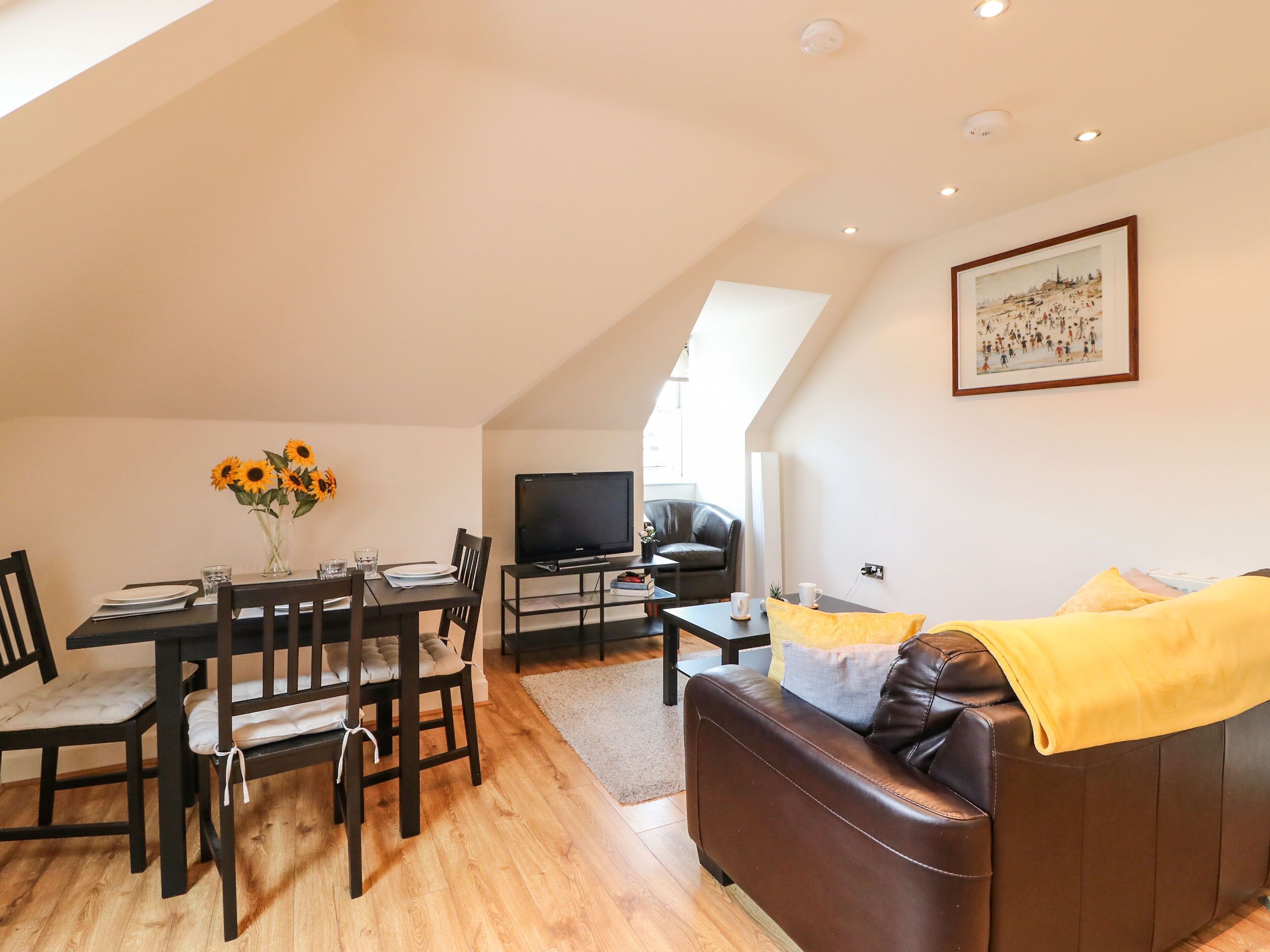 Um apartamento moderno no estilo loft, com área de jantar, sala de estar e uma grande janela.