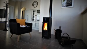 A modern living room with a black sofa, a fireplace, and a clock on the wall. - "La Casa De La Font" classified *** near Céret and Thuir  private parking (LLAURO)
