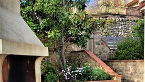 An outdoor kitchen area with a stone wall, wooden steps, and a fire pit. - "La Casa De La Font" classified *** near Céret and Thuir  private parking (LLAURO)