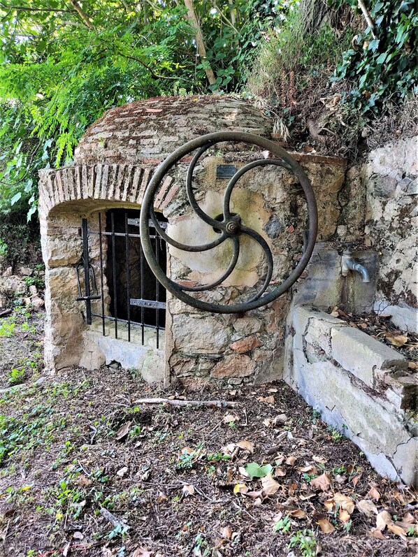 Una estructura rústica de piedra con una escalera espiral de metal.