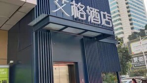 A hotel with a modern facade, featuring vertical slats and a prominent entrance. - Shenzhen Aige Hotel (Clothing Wholesale Market Nanyou Metro Station Store) (Shenzhen)