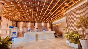 A reception area with a wooden ceiling, a reception desk, and potted plants. - Shenzhen Aige Hotel (Clothing Wholesale Market Nanyou Metro Station Store) (Shenzhen)
