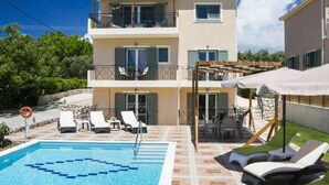 A two-story building with a swimming pool, outdoor seating, and a pergola. - Rose Villa in Svoronata (Kefalonia)