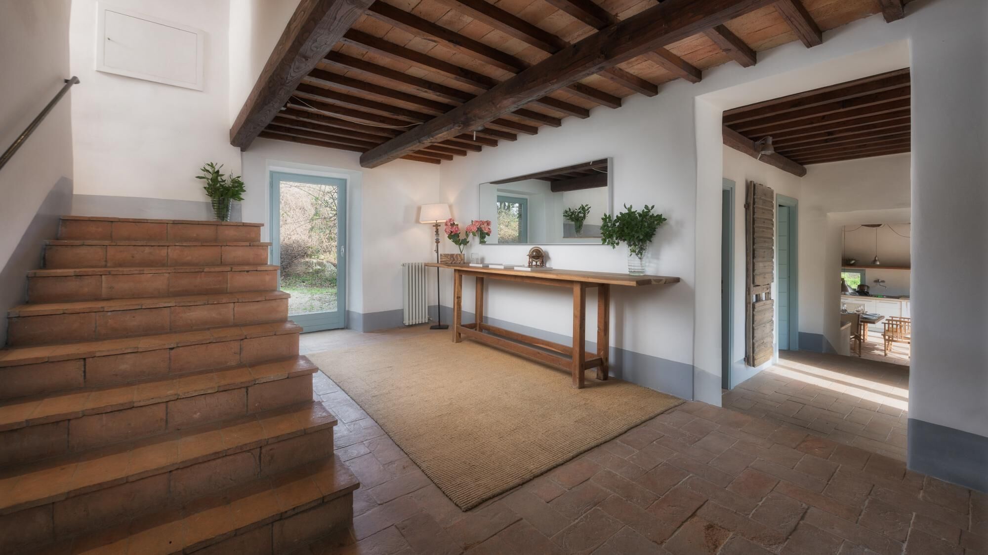 A staircase leading to a landing with a wooden bench and potted plants.