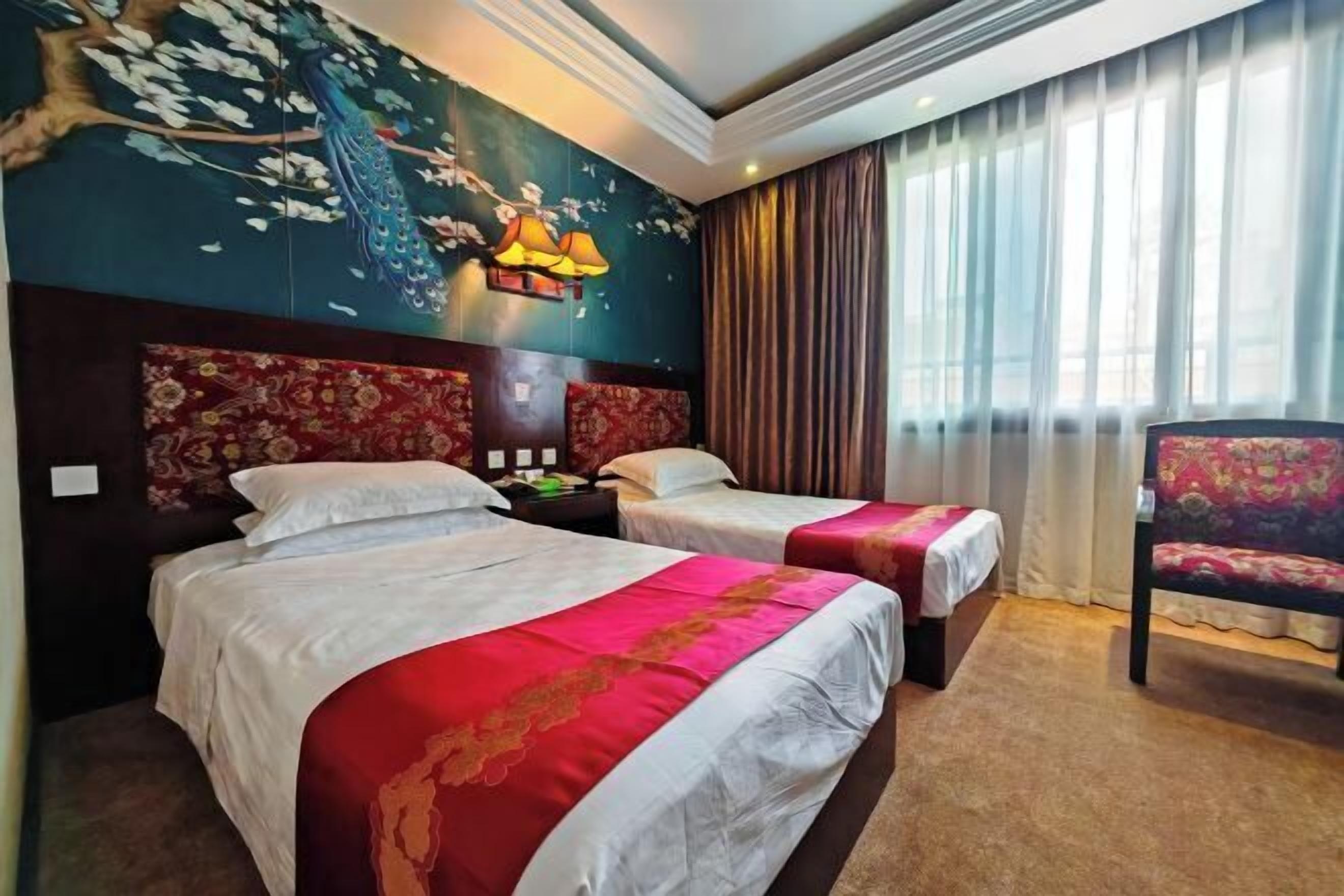 Habitación de hotel con dos camas, un mural grande en la pared, una silla y una ventana con cortinas.
