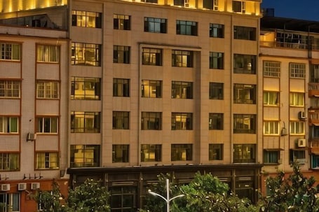 A multi-story hotel with a uniform facade, large windows, and a flat roof.. Ligang Hotel