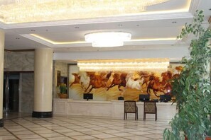 A lobby with a reception desk, a large chandelier, and a marble floor. - Ligang Hotel (Xishui)
