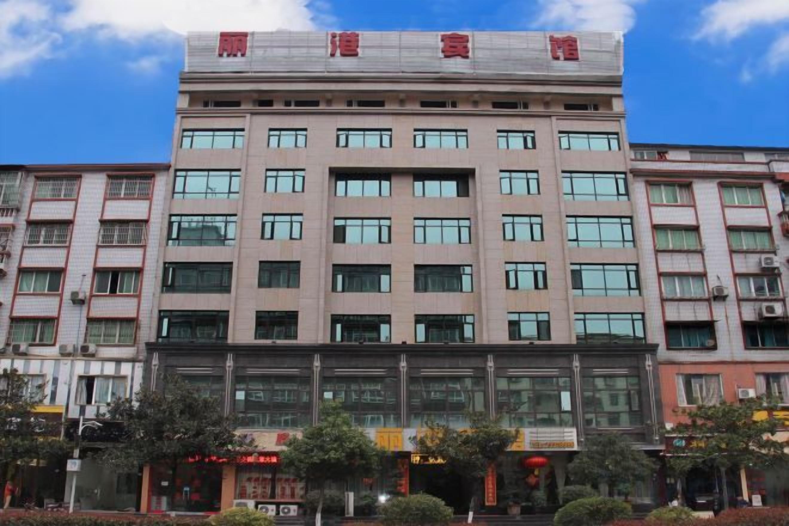 A multi-story building with a flat facade, large windows, and a sign with Chinese characters at the top.