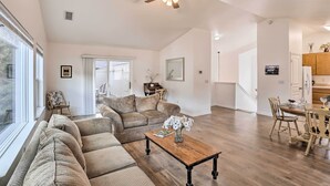 A spacious living room with a large sofa, a wooden coffee table, and a ceiling fan. - Mount Shasta Escape w/ Balcony ~ Walk to Dtwn (Mount Shasta)