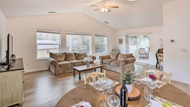 A spacious living room with two sofas, a coffee table, and a dining table set for six. - Mount Shasta Escape w/ Balcony ~ Walk to Dtwn (Mount Shasta)