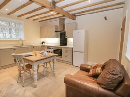 Una cocina compacta con una mesa de comedor, sillas, un sofá y un refrigerador.