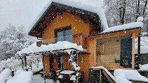 Een houten blokhut met een overdekte veranda en een sauna.