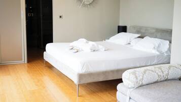Una habitación de hotel con una cama grande, una mesita de noche y un sofá.
