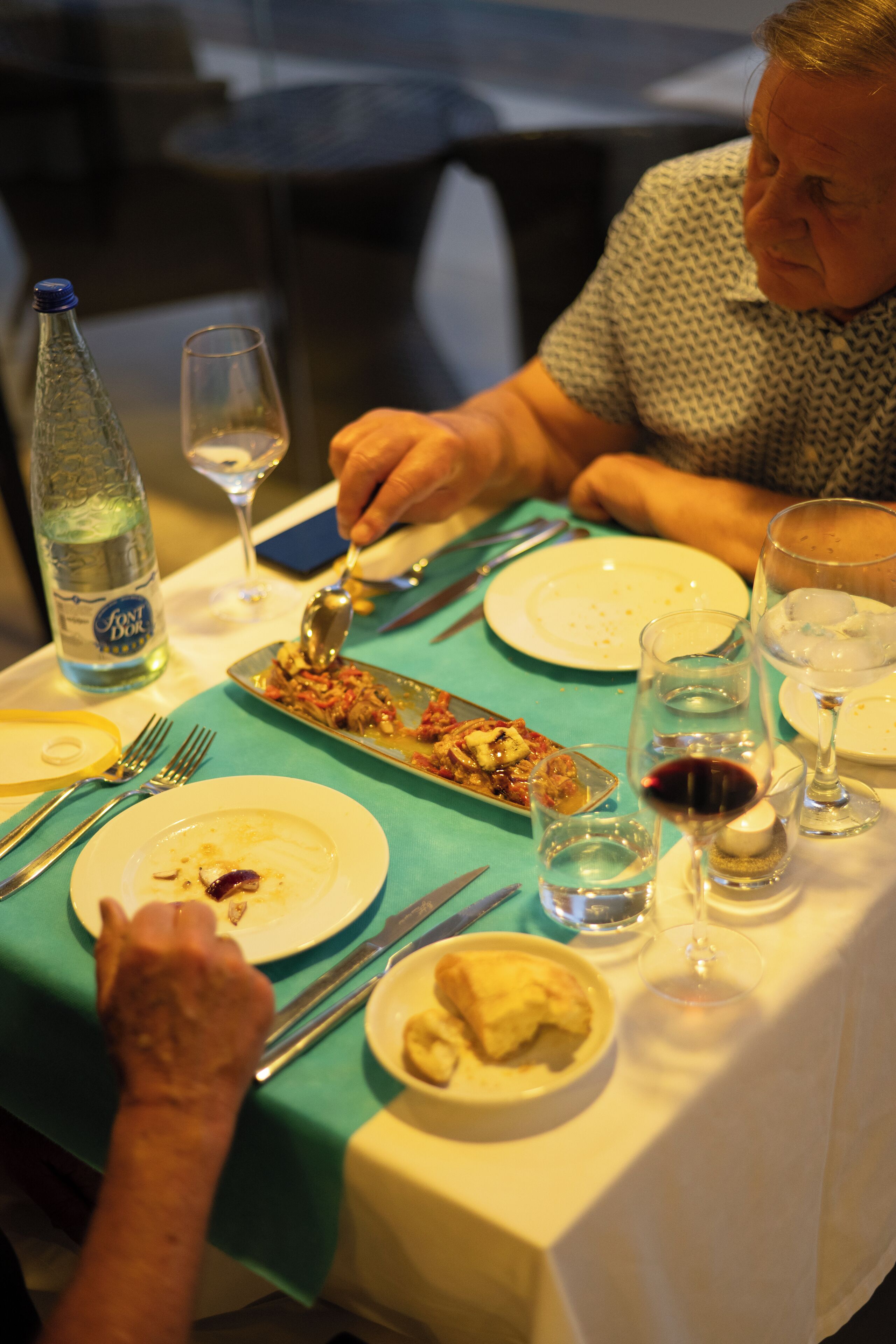 Une table à manger avec des assiettes, des couverts et des verres.