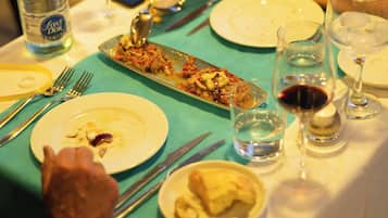 Une table à manger avec des assiettes, des couverts et des verres.