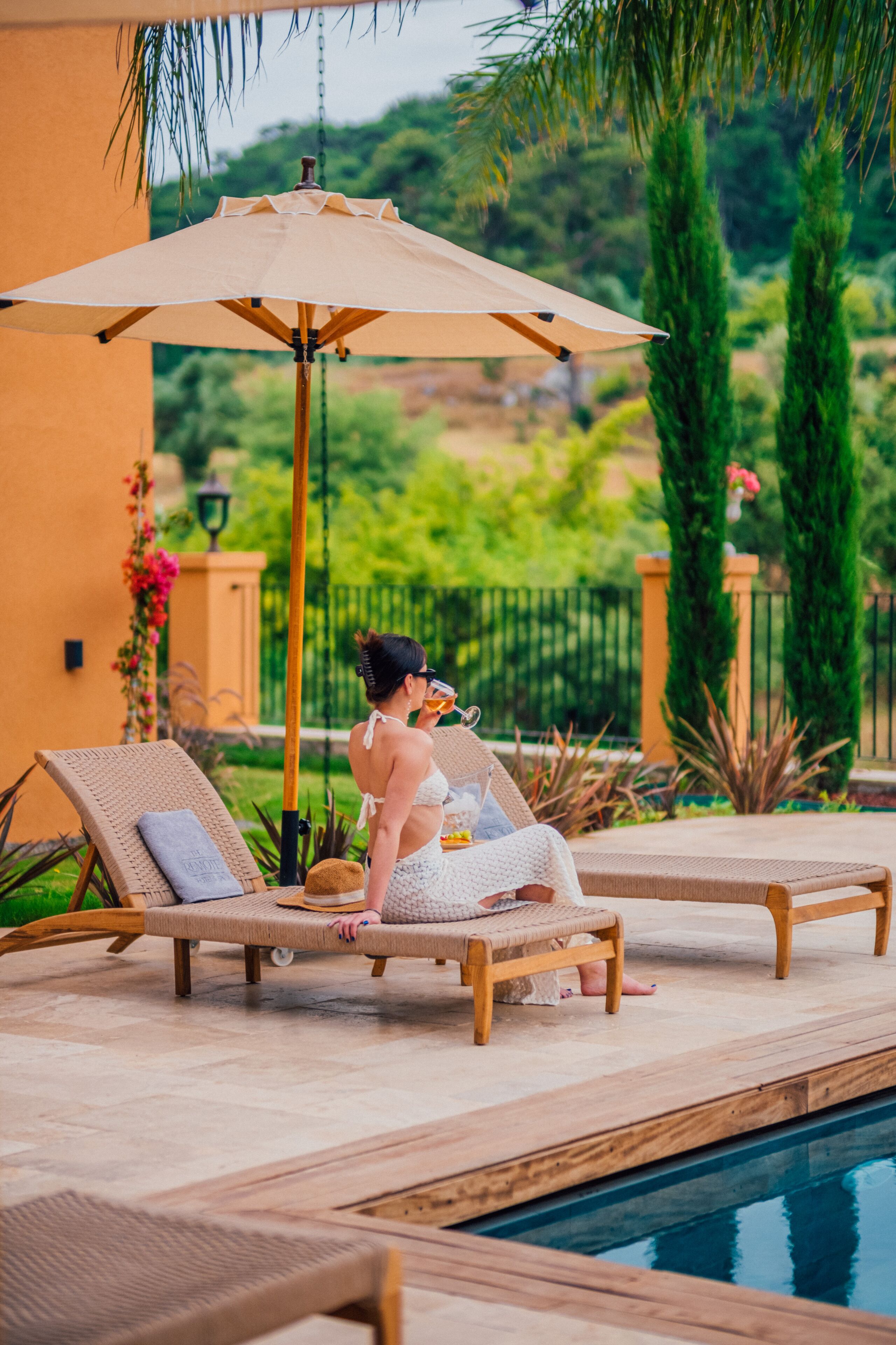 Un espace aménagé au bord de la piscine, avec des chaises longues et un grand parasol.
