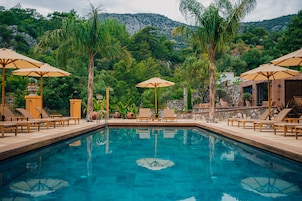 Una piscina al aire libre de temporada, sombrillas