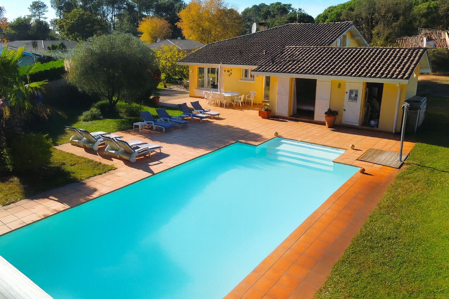 Vue aérienne de la piscine chauffée, de la terrasse ensoleillée et de la villa 