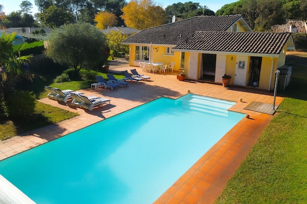 Vue aérienne de la piscine chauffée, de la terrasse ensoleillée et de la villa
