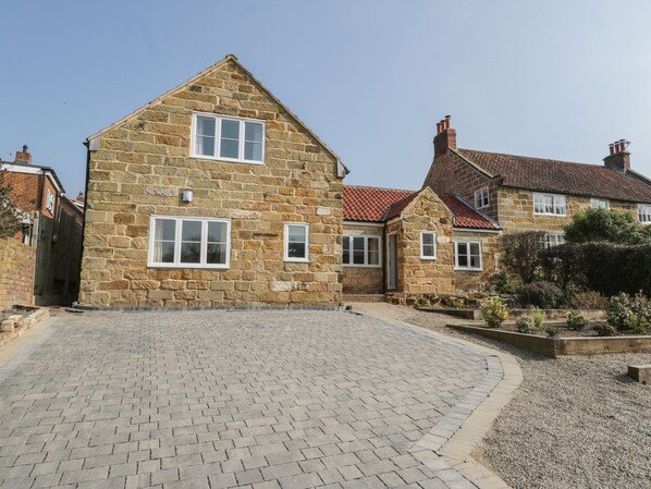 A stone house with a paved driveway and a small garden area. - Rose Cottage (Middlesbrough)