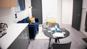 A compact living space with a kitchenette, a dining area, and a sofa.