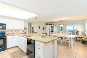 Enjoy meals in the well-lit kitchen and dining area with a central island, oven, and comfortable seating.