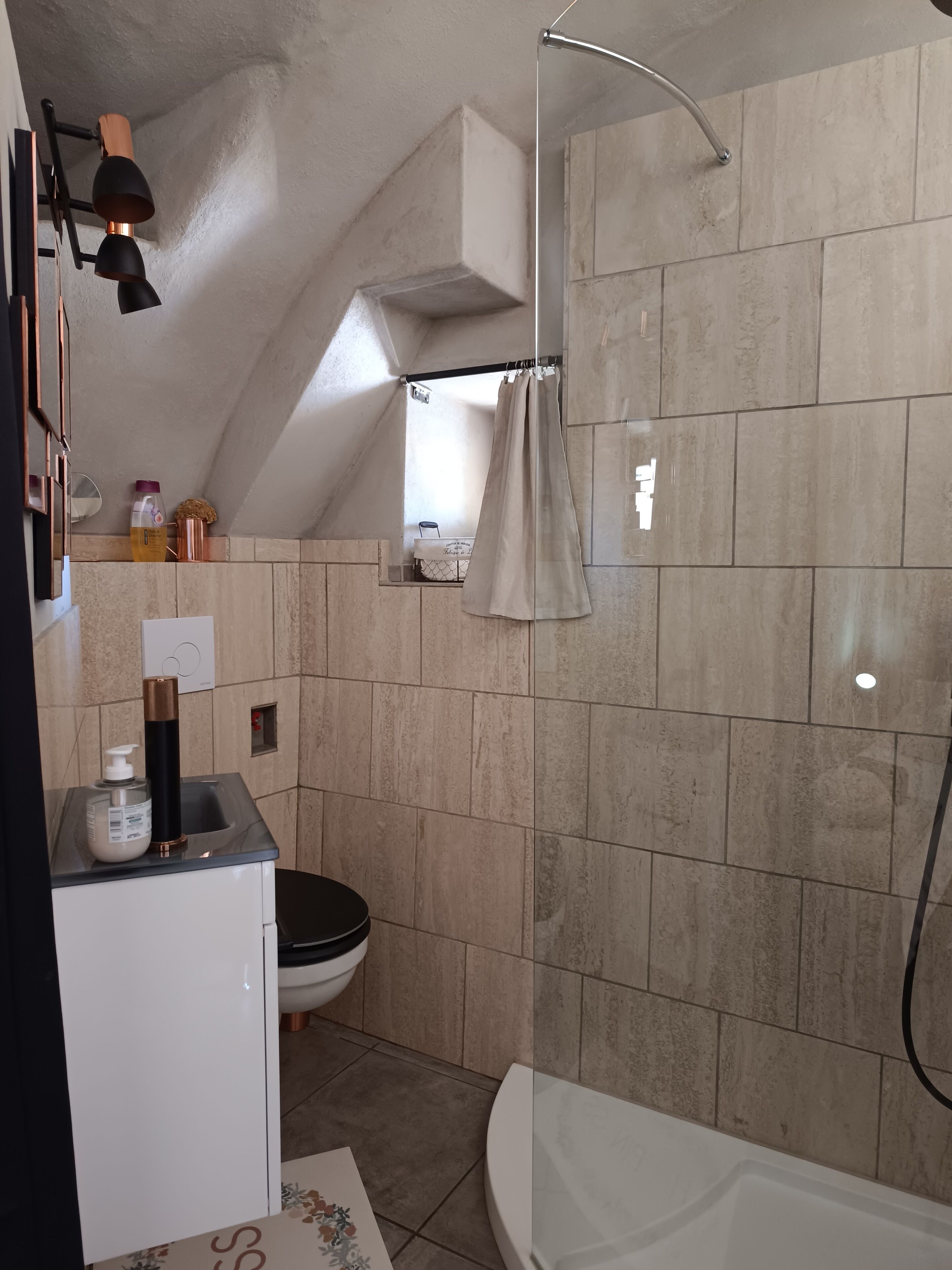 A compact bathroom with a shower, toilet, and sink.
