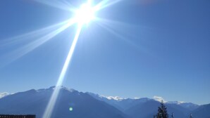 Eine Bergkette mit blauem Himmel und Sonnenschein.