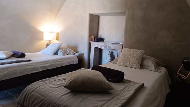 Ein gemütliches Schlafzimmer mit zwei Betten, einem Nachttisch und einer Lampe.