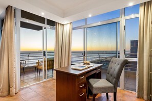 A modern room with a large window, a desk, and a chair, overlooking a scenic view. - Ocean View 701 (Cape Town)