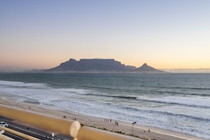A coastal view with a prominent hill, beach, and ocean.