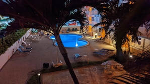 A pool area with lounge chairs and a circular pool, surrounded by palm trees and a building in the background. - Full Remodel, Direct Beachfront 3rd Floor Corner Unit, Fantastic Views! (Pompano Beach)