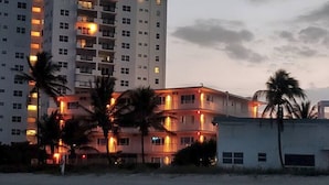 A multi-story hotel with balconies, palm trees, and a beach in the foreground. - Full Remodel, Direct Beachfront 3rd Floor Corner Unit, Fantastic Views! (Pompano Beach)