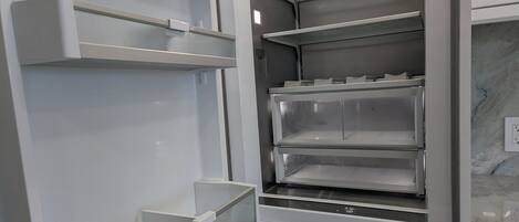 A modern kitchen with stainless steel appliances, multiple storage drawers, and a built-in oven.