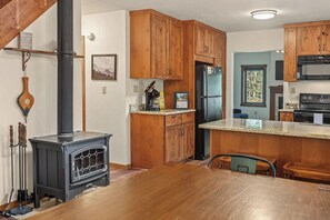 A kitchen with wooden cabinets, a black stove, and a refrigerator.