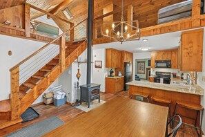 A spacious kitchen with wooden cabinets, a central island, and a stove. - Aspen Acre – Hot tub, wraparound deck, fireplaces & modern mountain charm! (Lead)