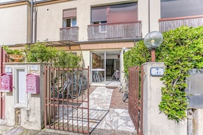 A building with a gated entrance, a balcony, and bicycles parked outside.