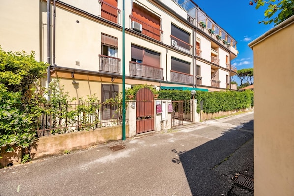 A multi-story residential building with balconies, a gated entrance, and a clear sky. - Terrazza Apuana A Few Steps From The Sea (Forte dei Marmi)