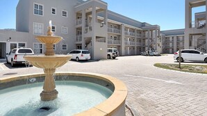A multi-story building with a central courtyard featuring a fountain. - Ocean Breeze 59 (Cape Town)