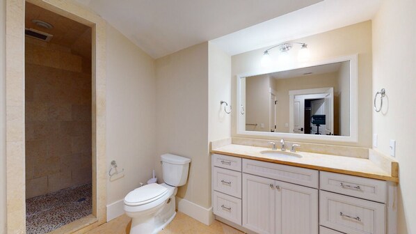 A bathroom with a toilet, sink, and shower area. - Large Golf Course View Home with Large Private Pool and Spa! (Hilton Head)