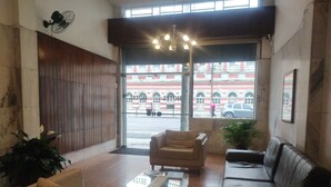 A hotel lobby with a reception desk, leather sofas, and potted plants. - Mônaco Hotel (Juiz de Fora)