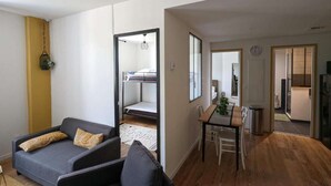 Ein kompakter Wohnbereich mit Sofa, Esstisch und Küchenzeile.