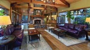 A spacious living room with a stone fireplace, leather sofas, and a chandelier. - Amazing Resort - Pools, Hot Tub, Hiking, 10 min to Bend and Bachelor (Bend)