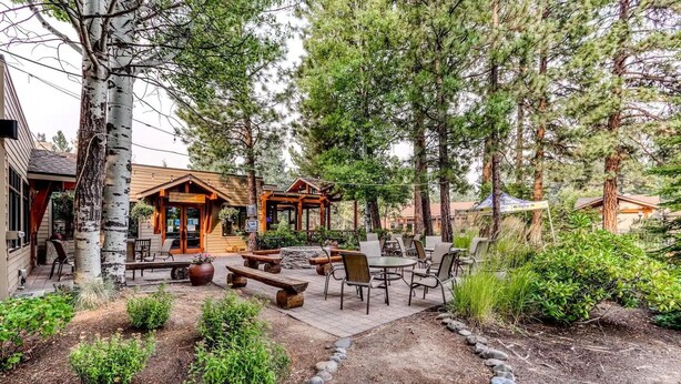 A rustic lodge with outdoor seating, a stone pathway, and a natural forest backdrop. - Amazing Resort - Pools, Hot Tub, Hiking, 10 min to Bend and Bachelor (Bend)