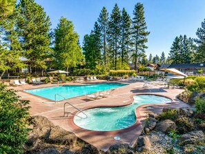A pool area with multiple swimming pools, lounge chairs, and a hot tub.