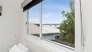 Enjoy a serene view of the surrounding landscape from the large window in this bathroom.