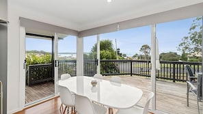 Enjoy meals or gatherings in this open-plan living space with a sliding glass door leading to an outdoor deck.