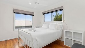 Relax in a serene space with a large bed and expansive views of the outdoors through large windows.