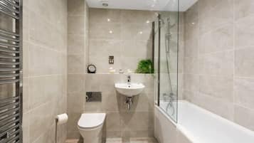 Bathtub, hair dryer, towels, shampoo