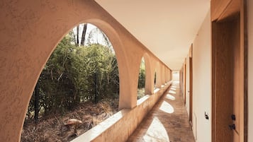 Un pasillo con arcos, un sendero y puertas de madera.